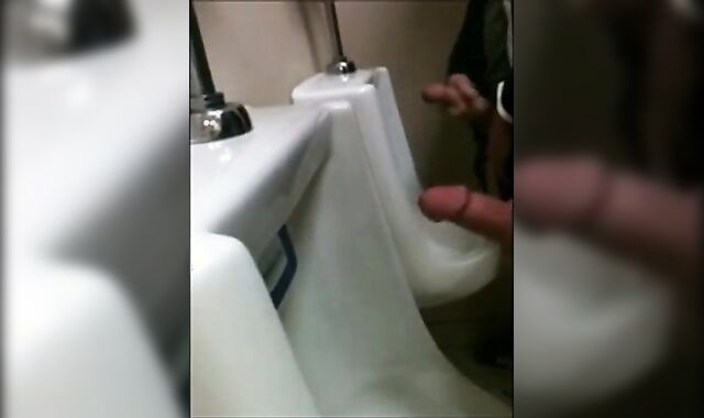 two slim dicks getting wanked at the urinals