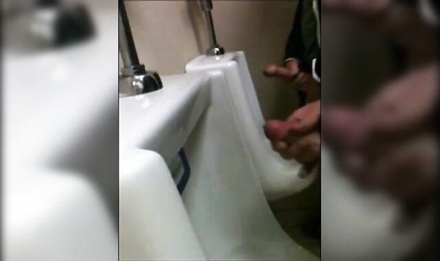 two slim dicks getting wanked at the urinals