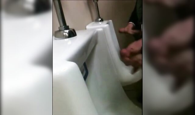 two slim dicks getting wanked at the urinals