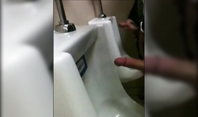 two slim dicks getting wanked at the urinals