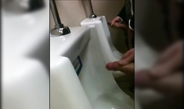 two slim dicks getting wanked at the urinals