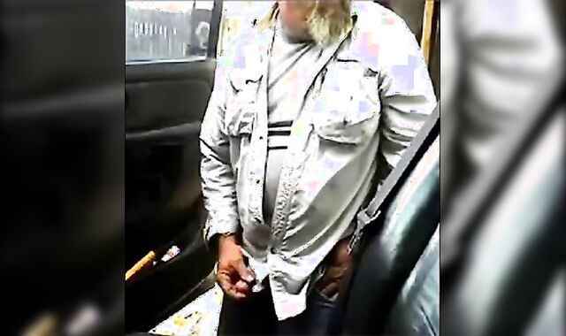 Bearded daddy strokes his cock by his truck outdoors.